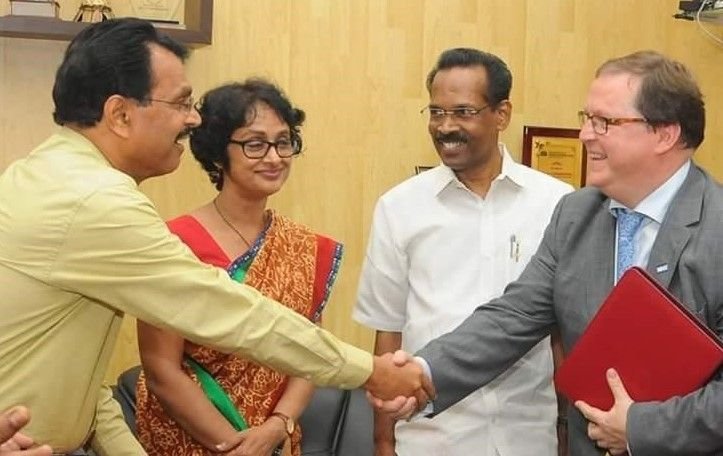 Jonathan Brown shaking hands with the Keralan Health Minister in Kerala, India