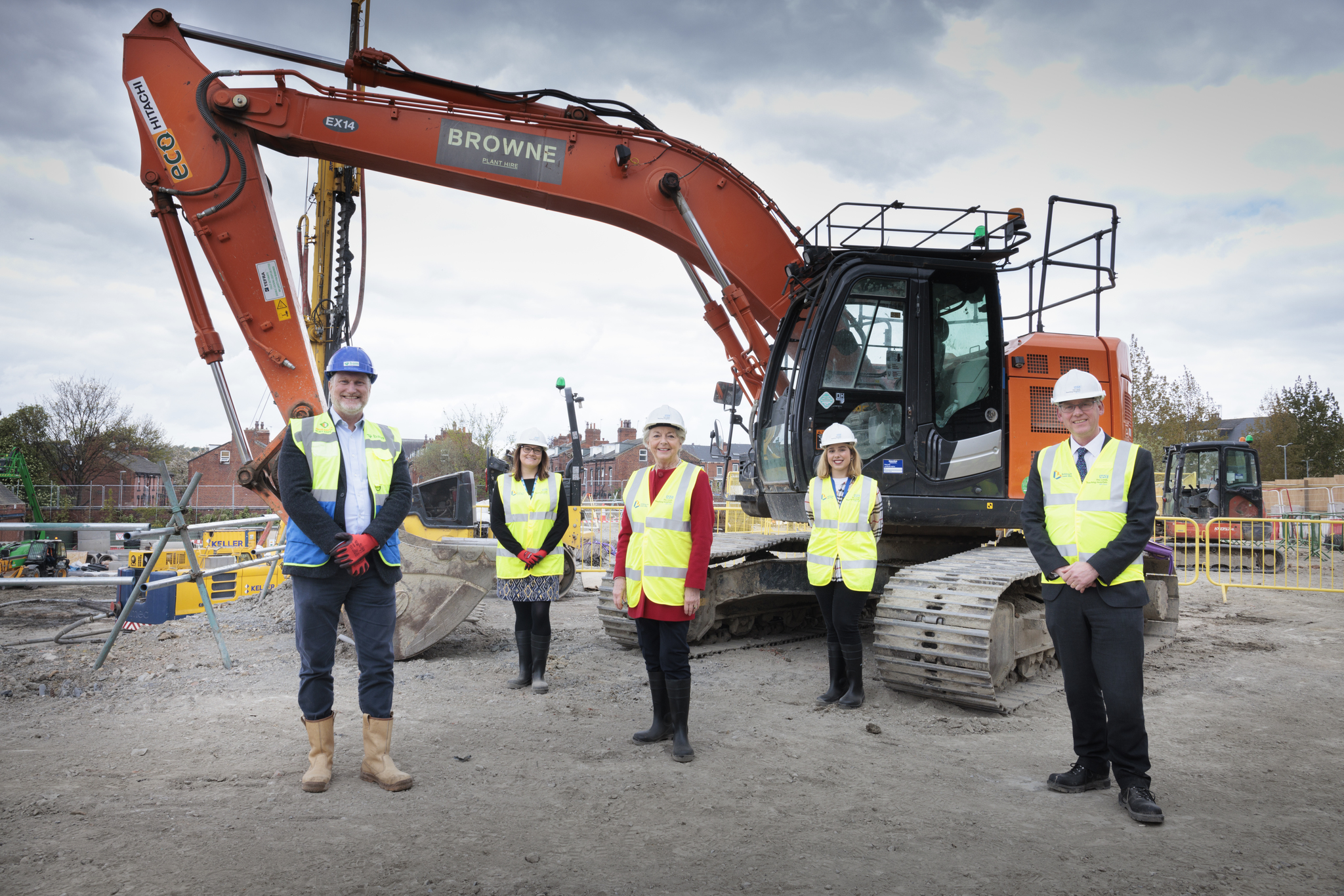 Start of construction Leeds pathology lab - collegaues standing at the site wearing safety helmets and high visibility clothing