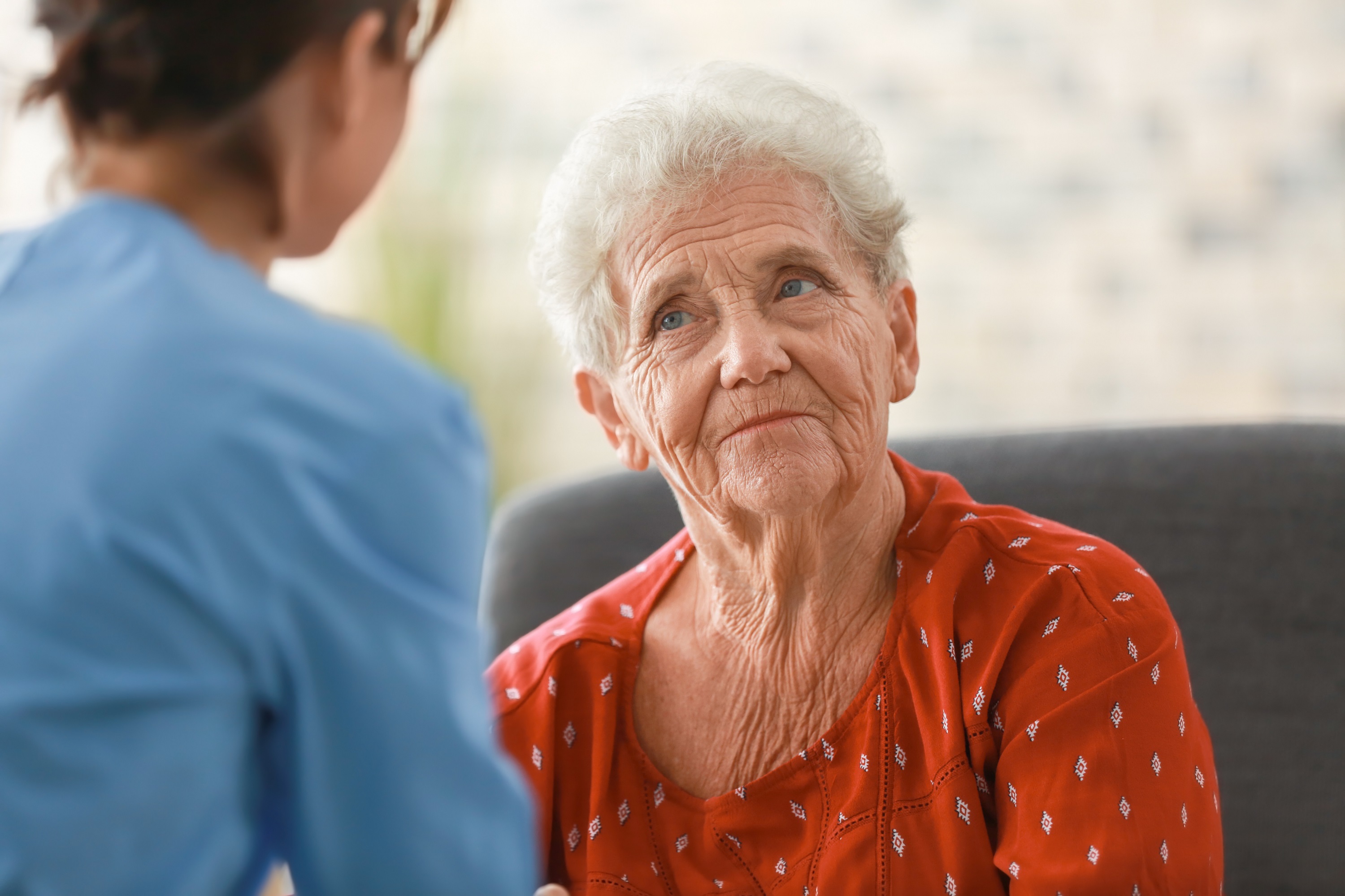 Photo of a female resident in a care home talking to a female nurse