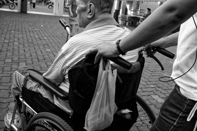 working carer pushing a wheelchair