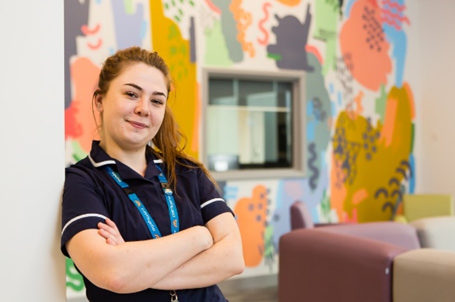 Smiling staff member with arms crossed