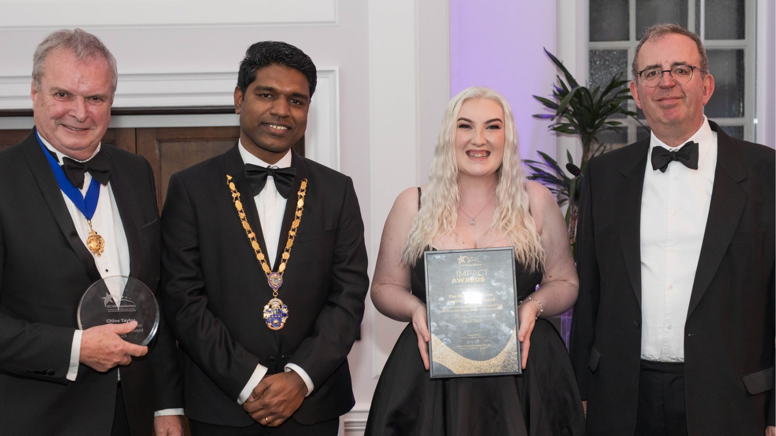 Image of people smiling with an award