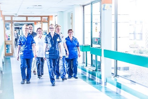 a group of nurses striding down a hospital corridor