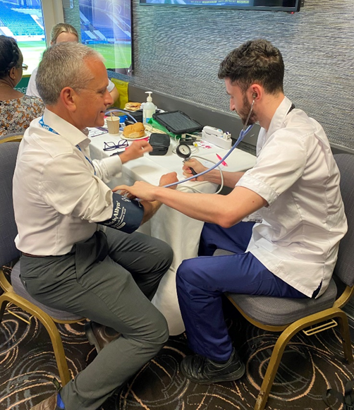 Robin Tuddenham having his blood pressure checked by a member of the University of Huddersfield’s get set goal team - Robin is Place Lead for Calderdale for NHS West Yorkshire Integrated Care Board, and is joint SRO of the Improving Population Health Programme