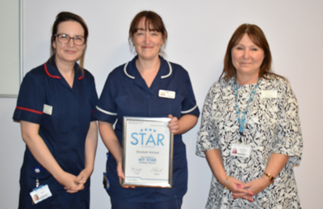 Libby with her Star award, flanked by two colleagues