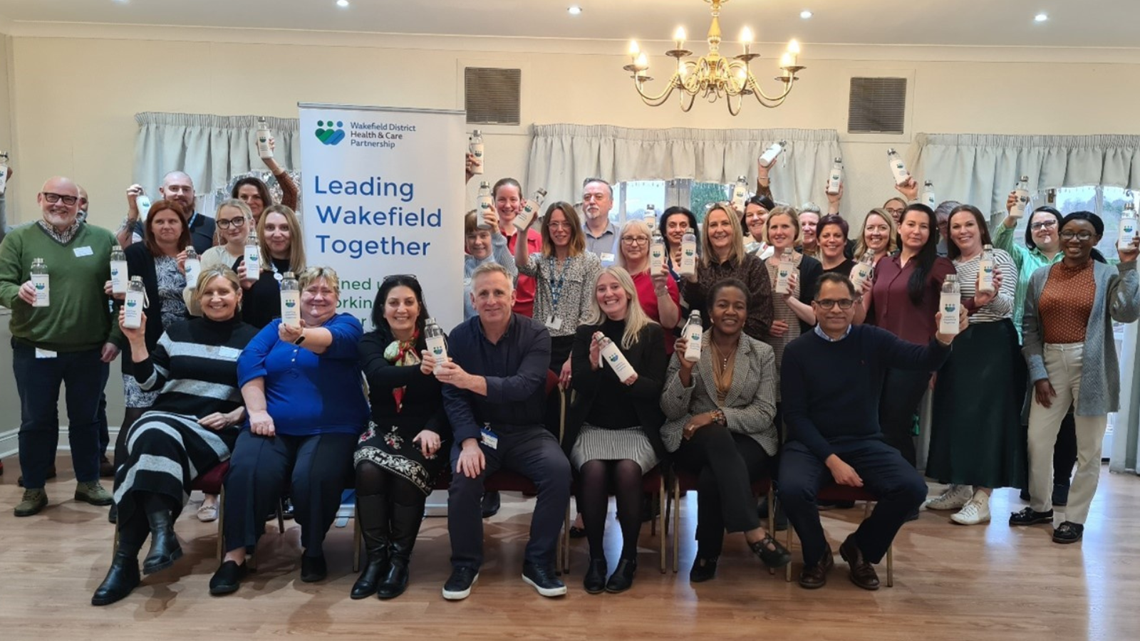 Group of people in front of sign that says Leading Wakefield Together