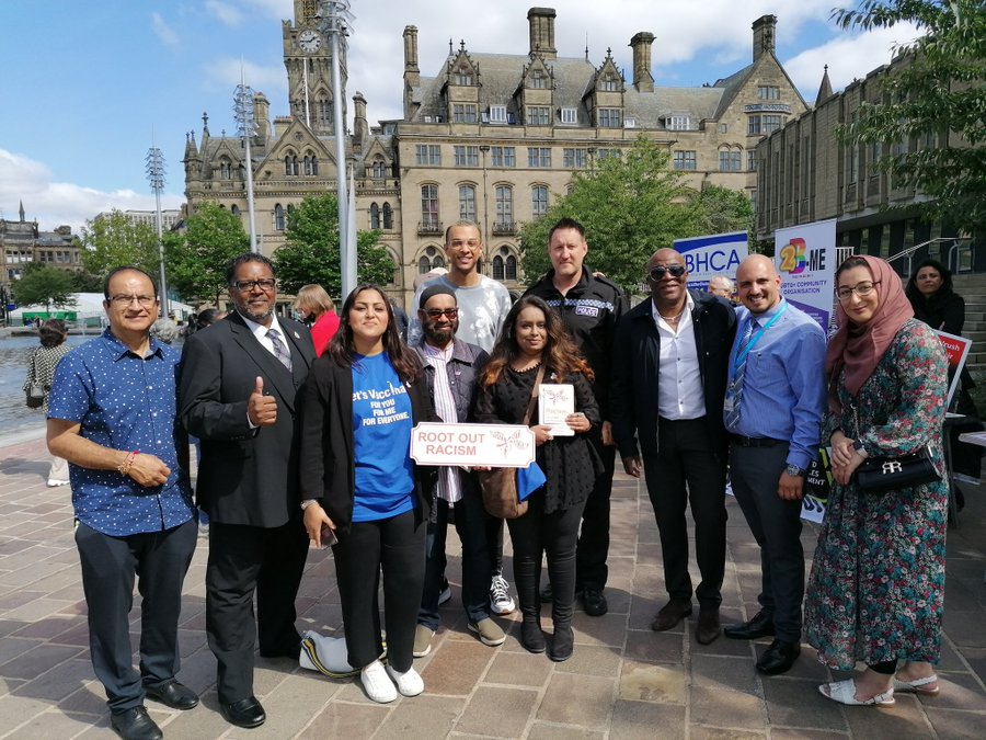 Bradford heath and care and council leaders holding 'Root Out Racism' anti-racism signs