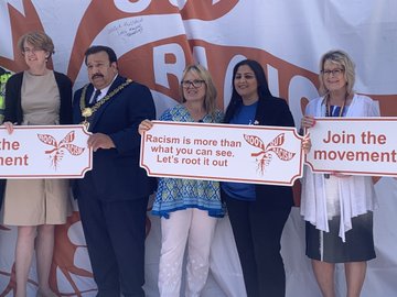 Bradford heath and care and council leaders holding 'Root Out Racism' anti-racism signs