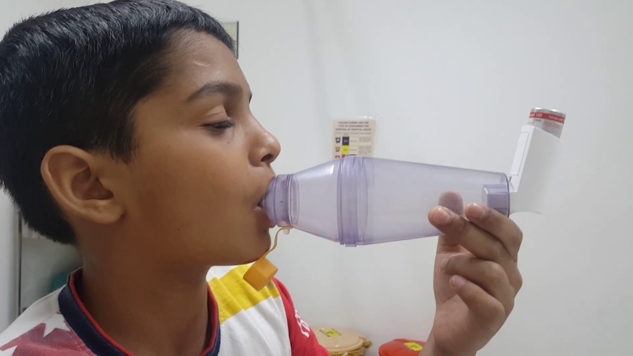 Child using an inhaler with spacer 