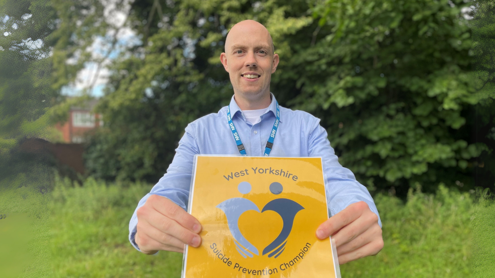 Image of man holding sign with text: Suicide prevention champion