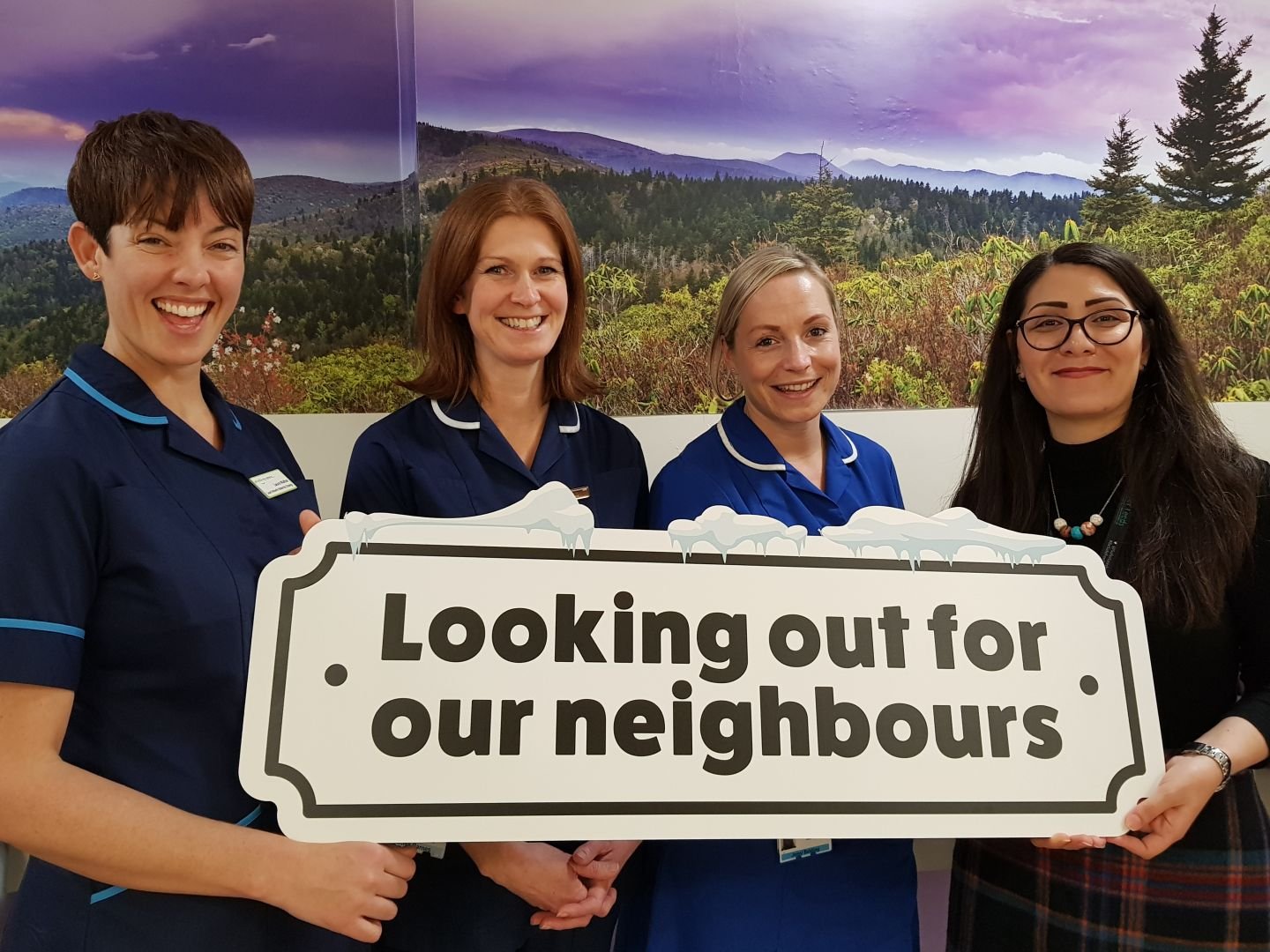 Nurses with "looking out for our neigbours" sign