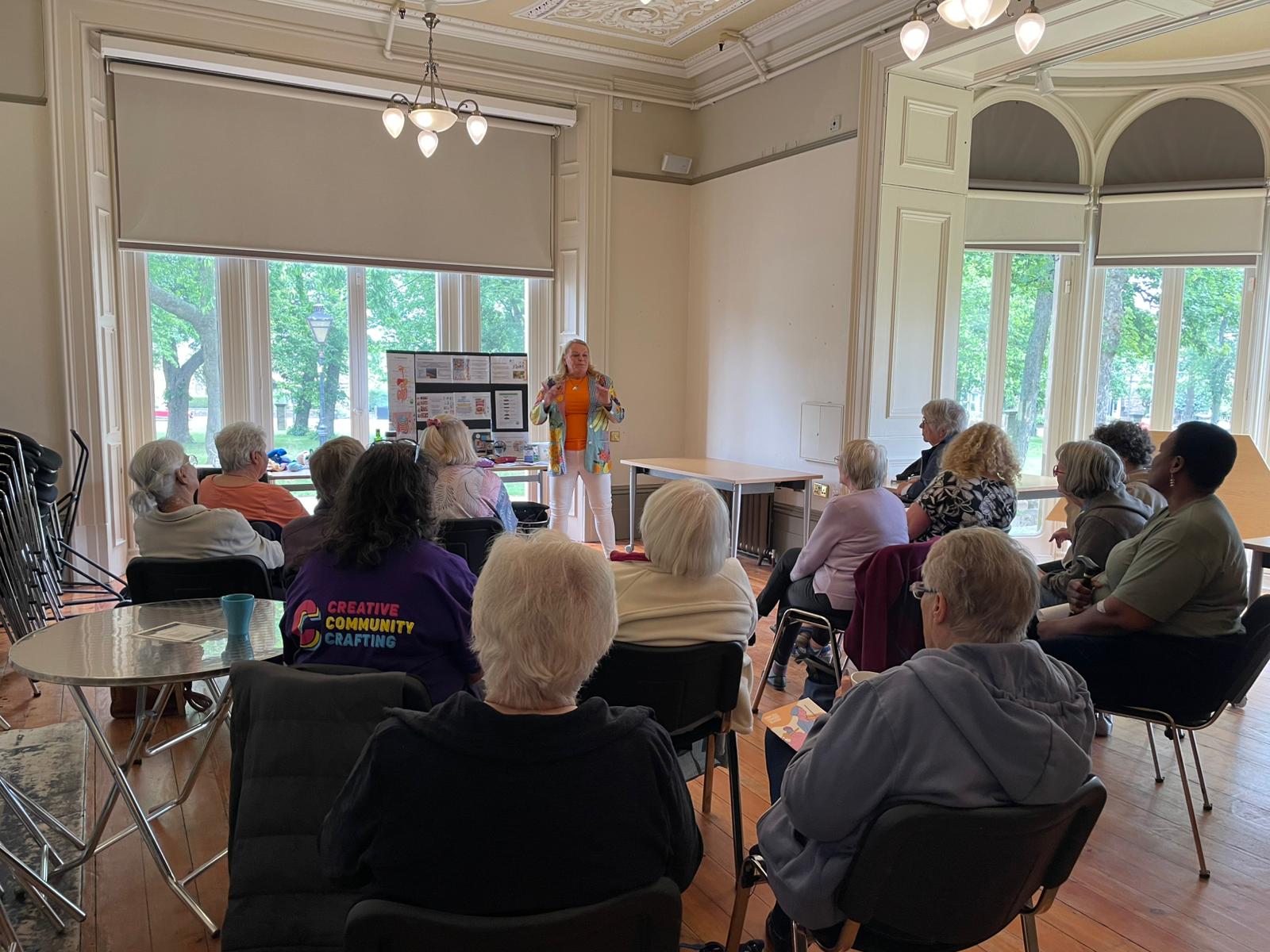 A community champion presenting to a room full of people