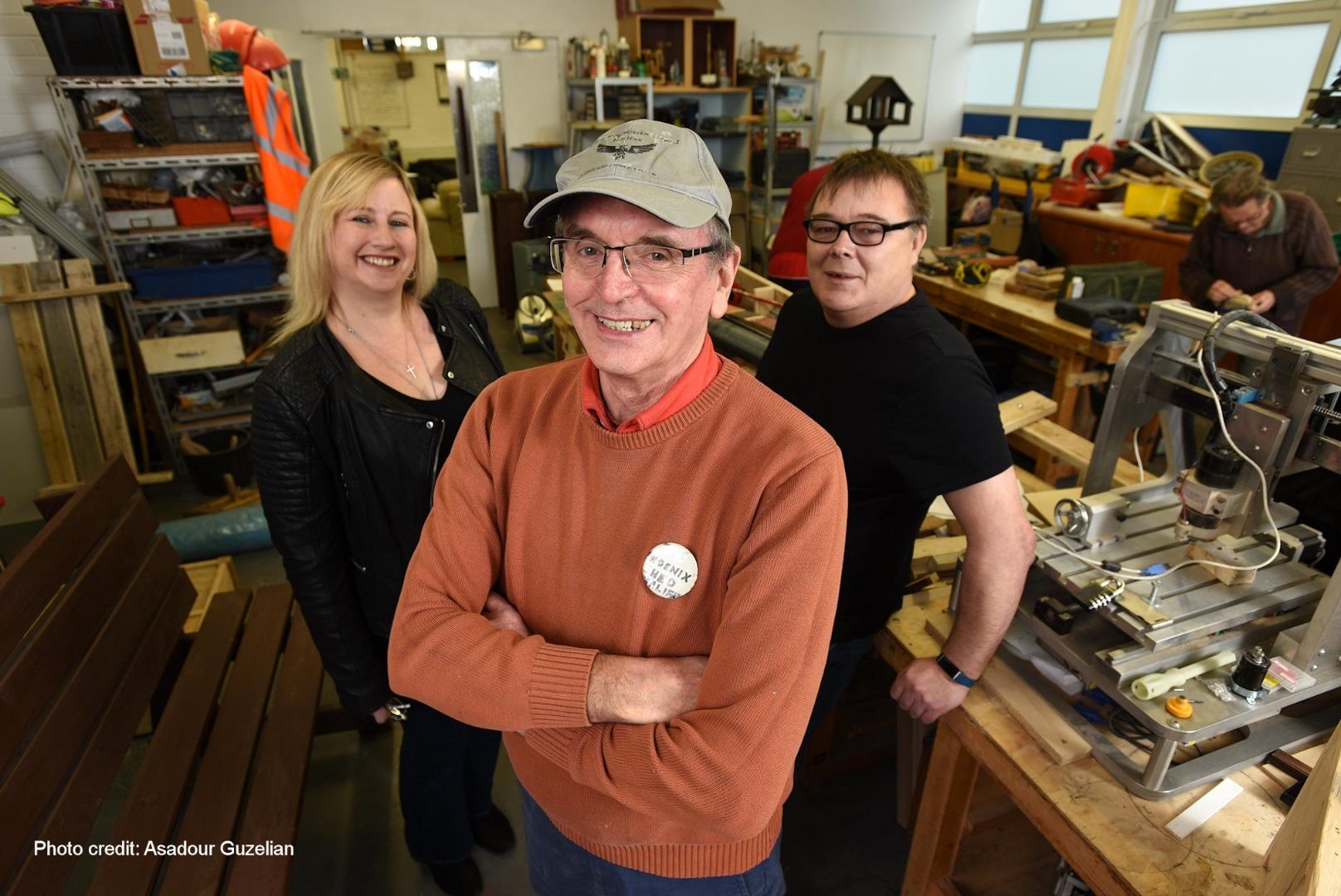 Three people standing in a workshop