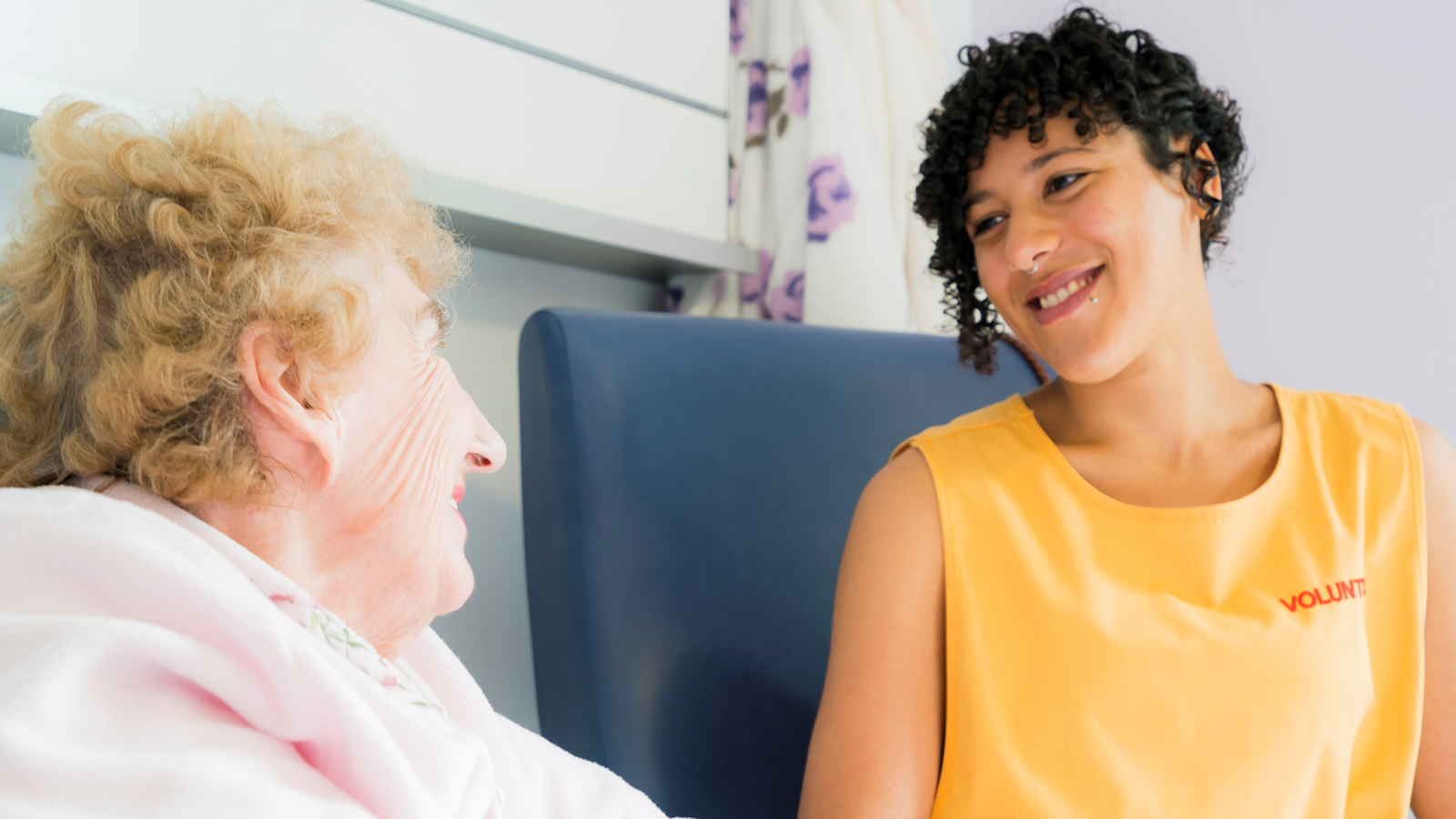 hospital volunteer chatting to a patient