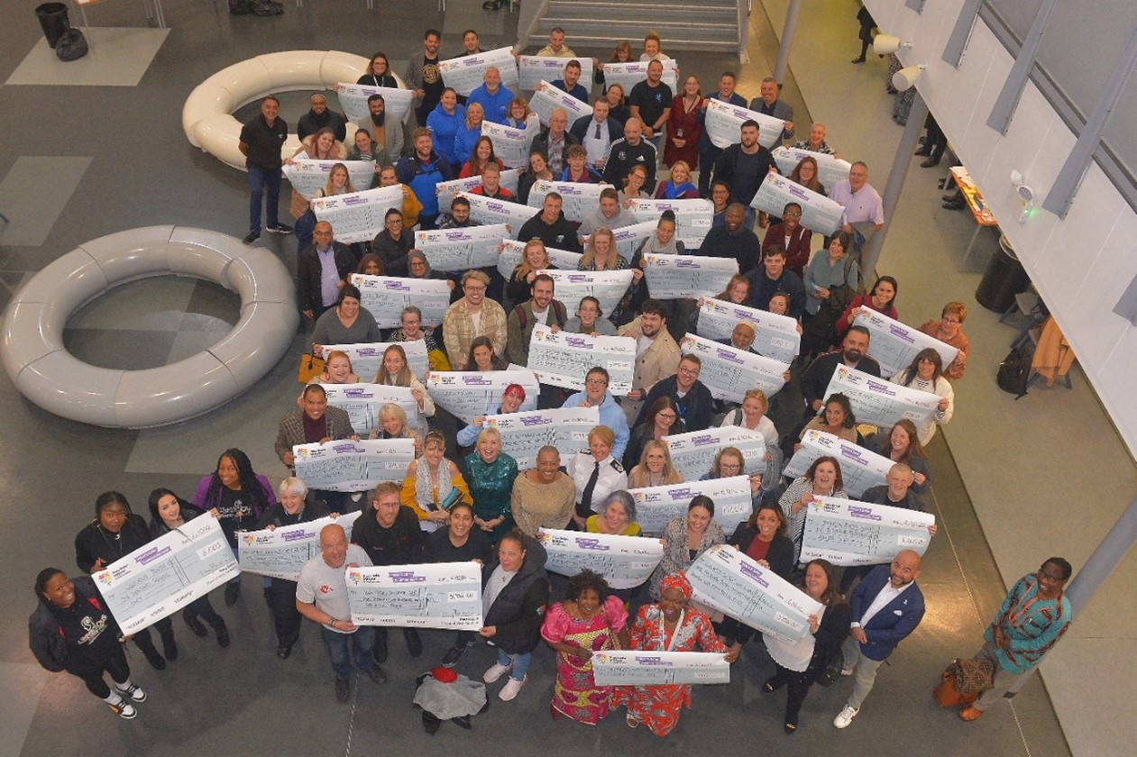 VCSE organisations with giant cheques showing their funding