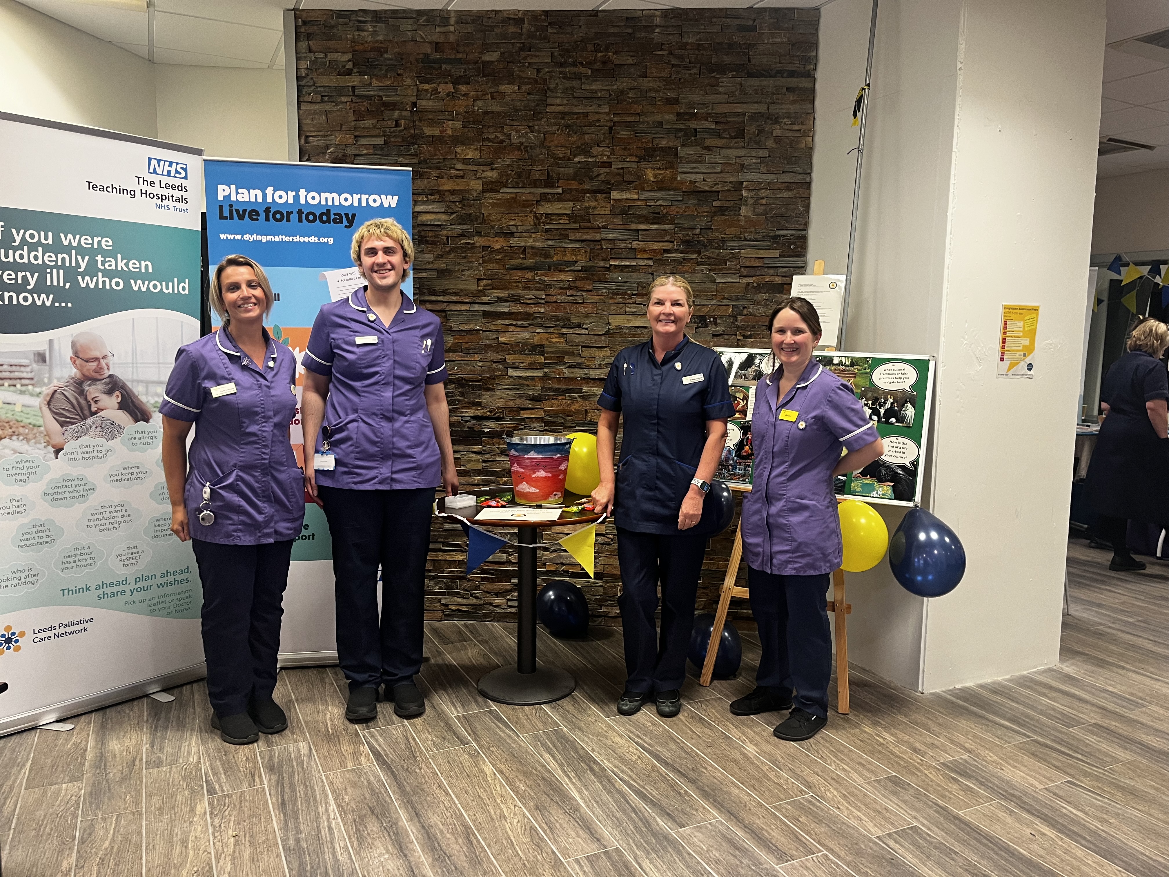 A group of four health care workers next to an exhibition stand