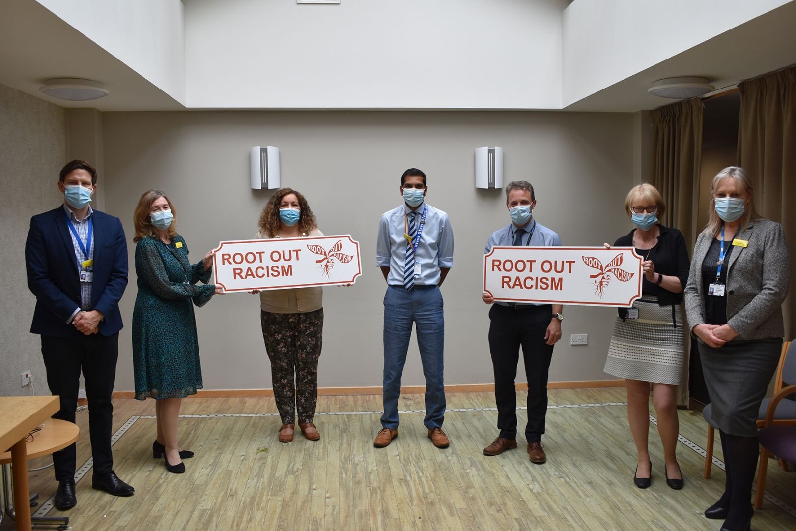 HDTF senior team holding a Root Out Racism sign prop