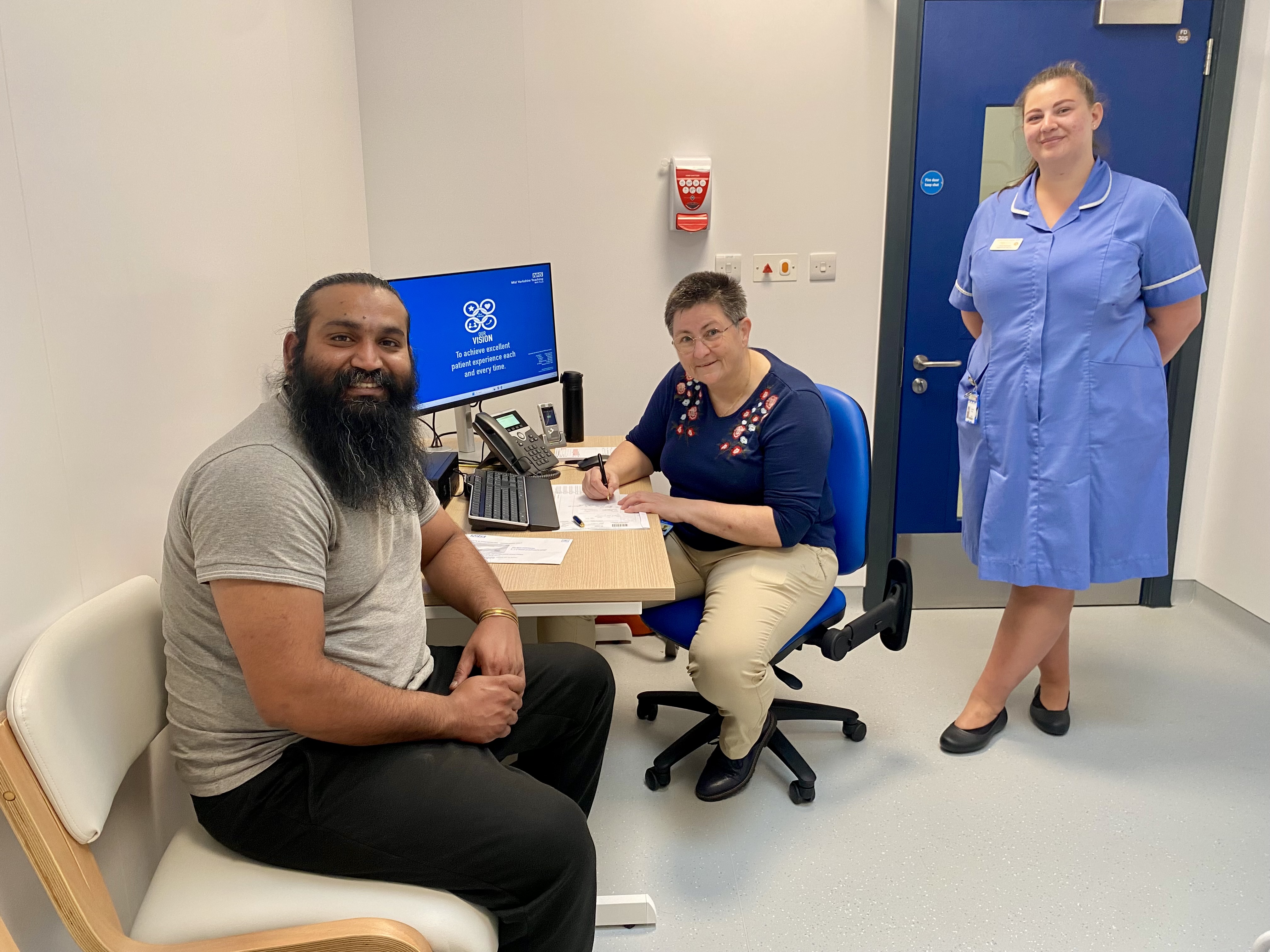 Image of people smiling at a desk, and a woman stood in nurse uniform