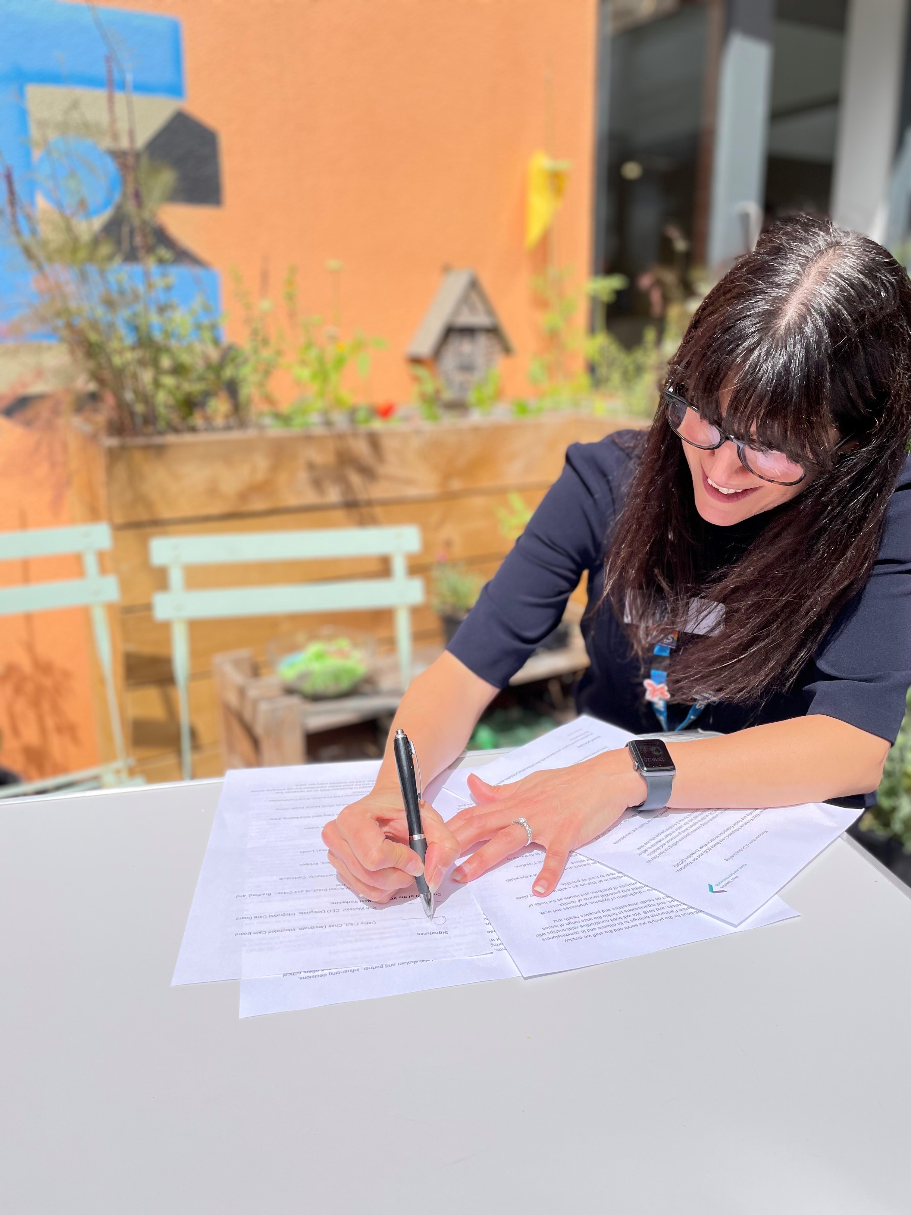 Cathy Elliott, NHS West Yorkshire Integrated Care Board Chair, signs memorandum of understanding with voluntary and community partners