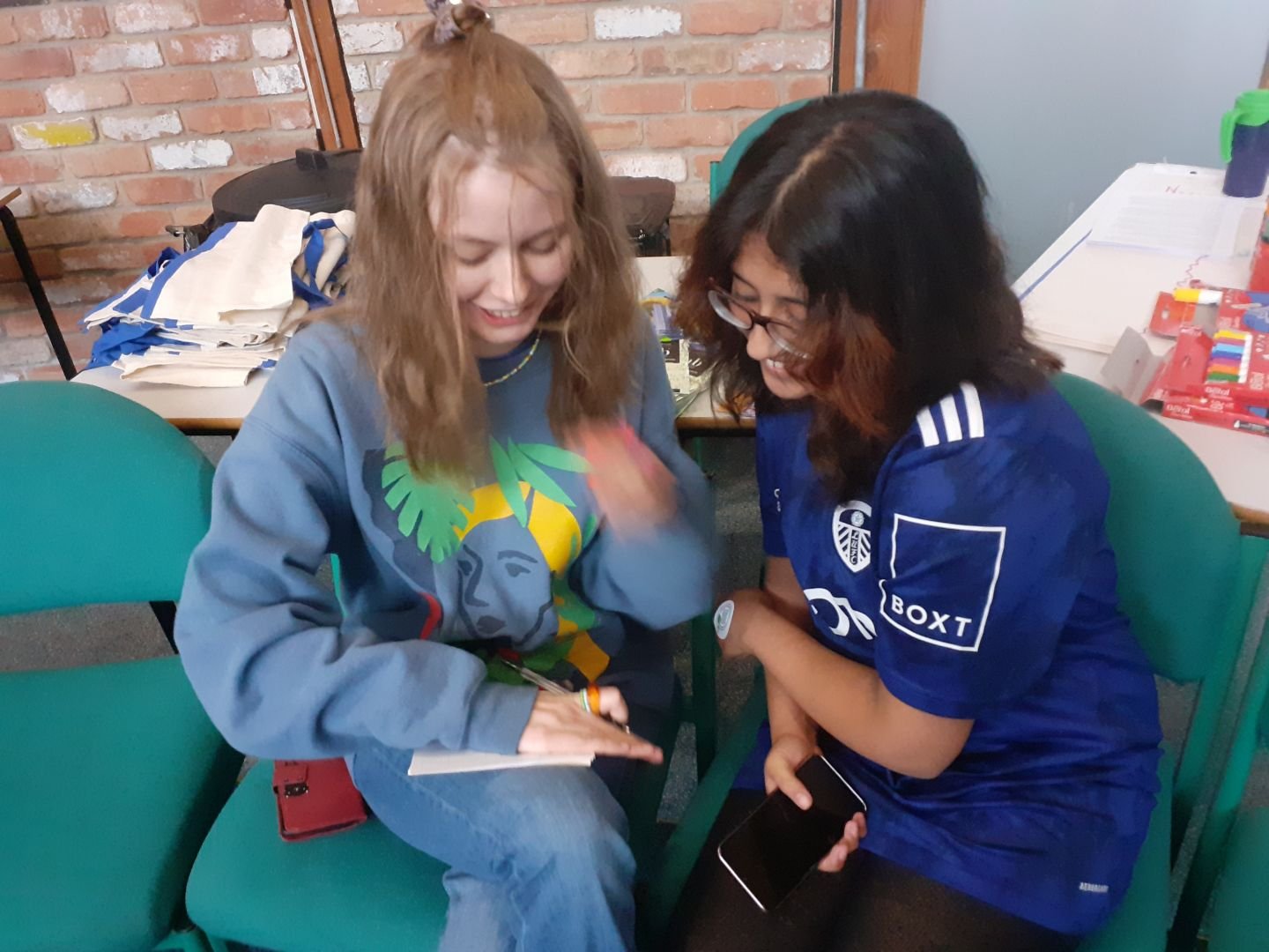 Two young people writing a postcard