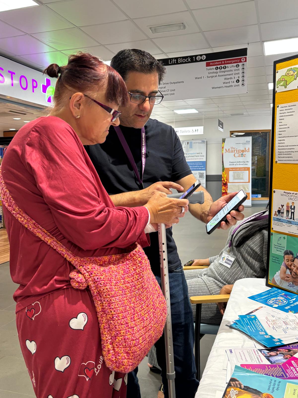 Two people talking in front of a display looking at mobile phones